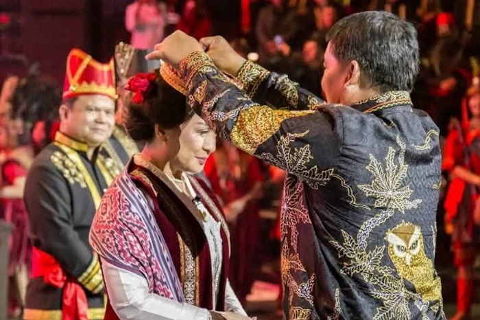Angelica Tengker menerima Pataka KKK dari Theo L. Sambuaga, simbol sah kepemimpinan budaya dan harmoni baru diaspora Minahasa. (Instagram.com @vidiwowor)